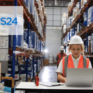 woman at table wearing safety gear while working on laptpo